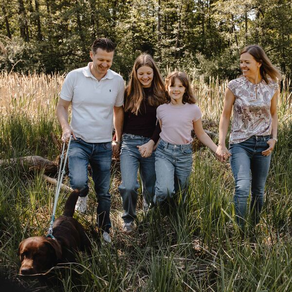 Familie mit Hund beim Ausflug in die Natur