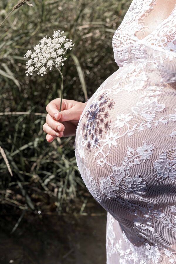 Schatten einer Blume auf dem Babybauch