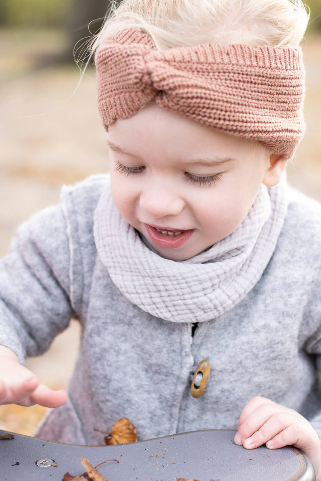 Ein Kind spielt mit Laub bei einem Shooting mit der Familienfotografin im Nürnberger Land.